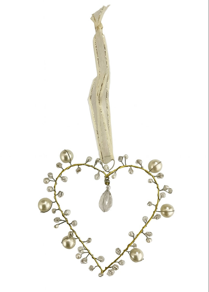 Heart-shaped decorative ornament with pearls and a ribbon on a white background