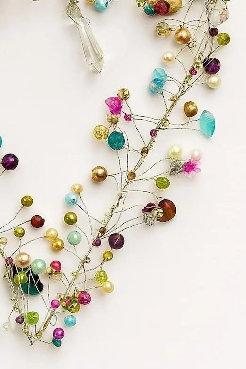 Decorative garland with multicolored beads and crystals on a white background