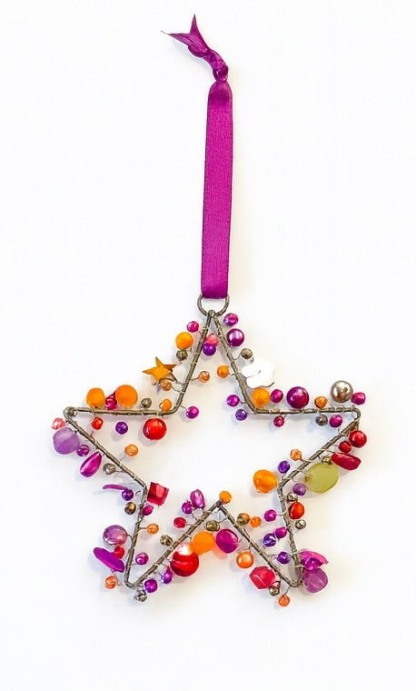 Decorative star ornament with colourful beads and a pink ribbon on a white background