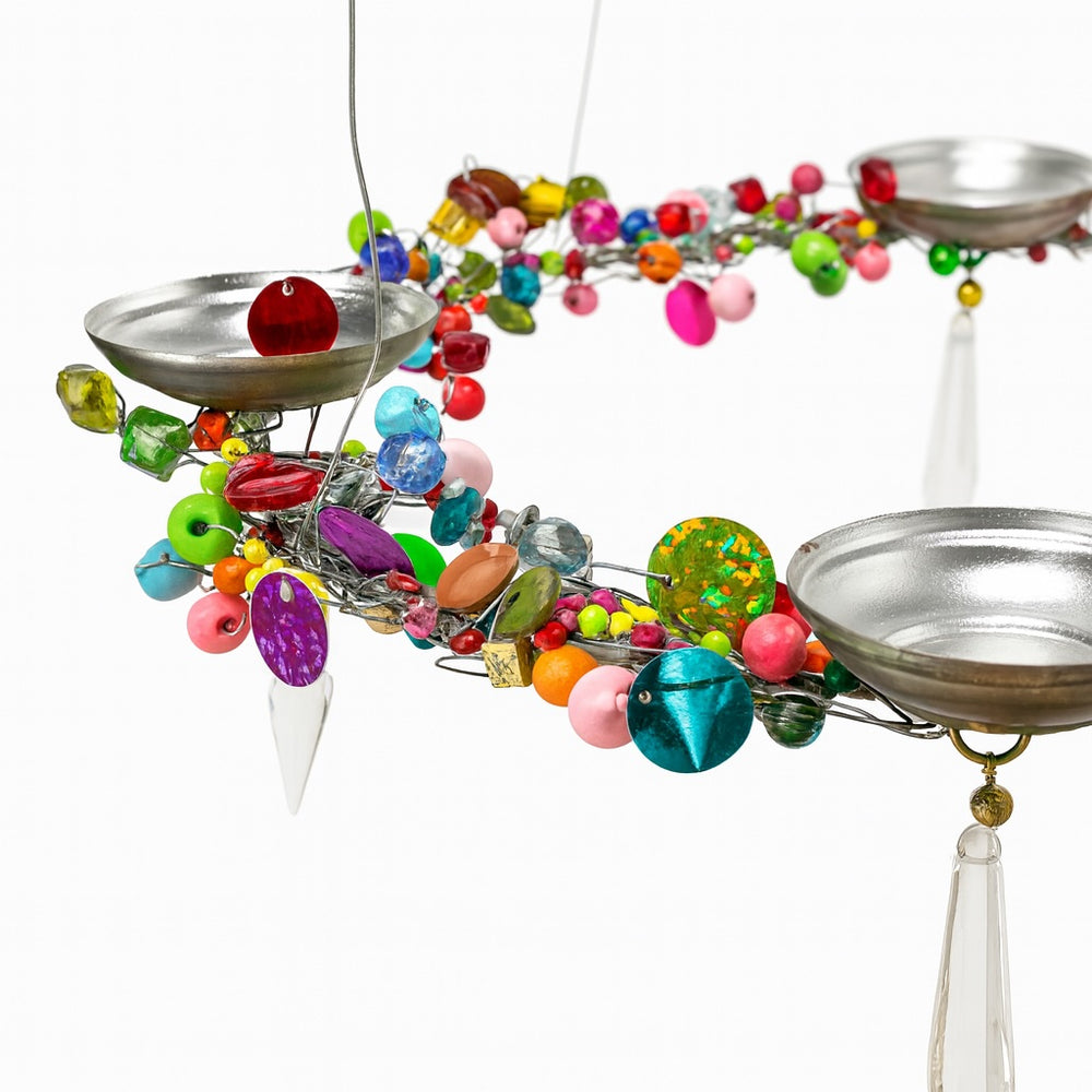 Colourful beaded hanging decoration with metal t light bowls on a white background