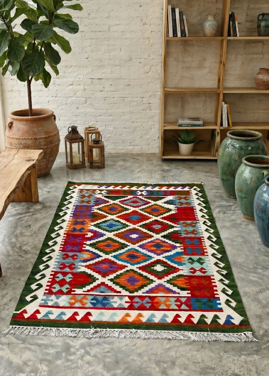 Colourful geometric-patterned rug on a concrete floor with a wooden bench and bookshelf in the background.