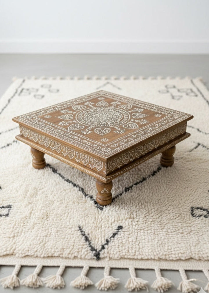 Decorative wooden table with intricate patterns on a textured rug