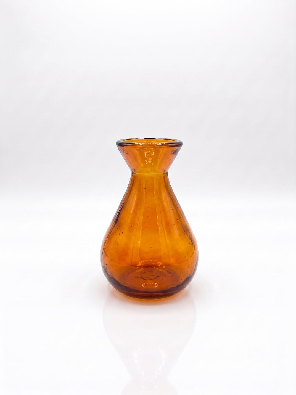 An amber glass vase with a flared rim and a rounded body, shown on a clean white background with a soft reflection below.