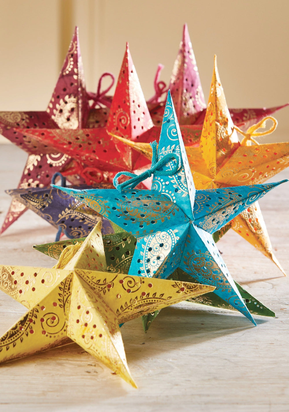 Colourful paper star decorations on a wooden surface