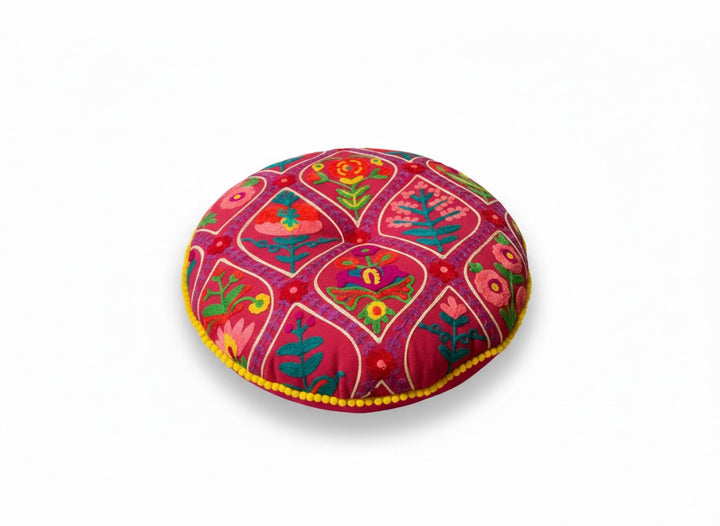 Decorative round pillow with pink colourful floral patterns on a white background