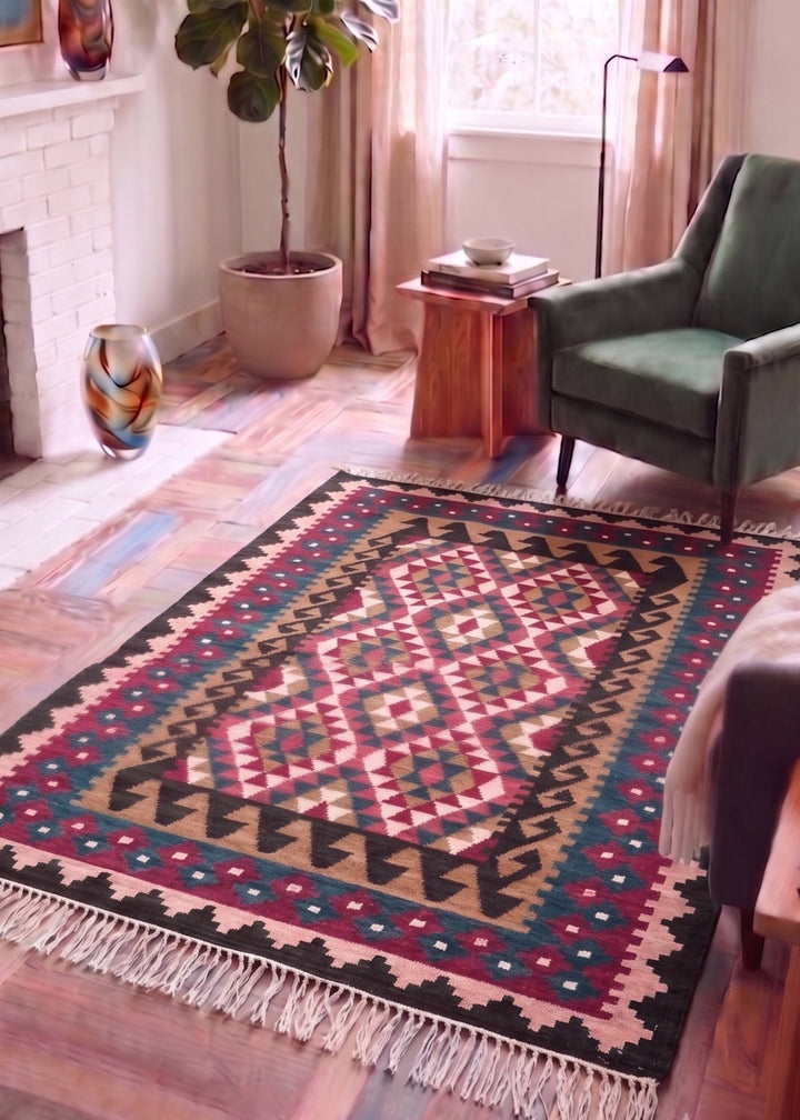 Pink Blue Kilim with geometric pattern in a room with a green chair and plant.
