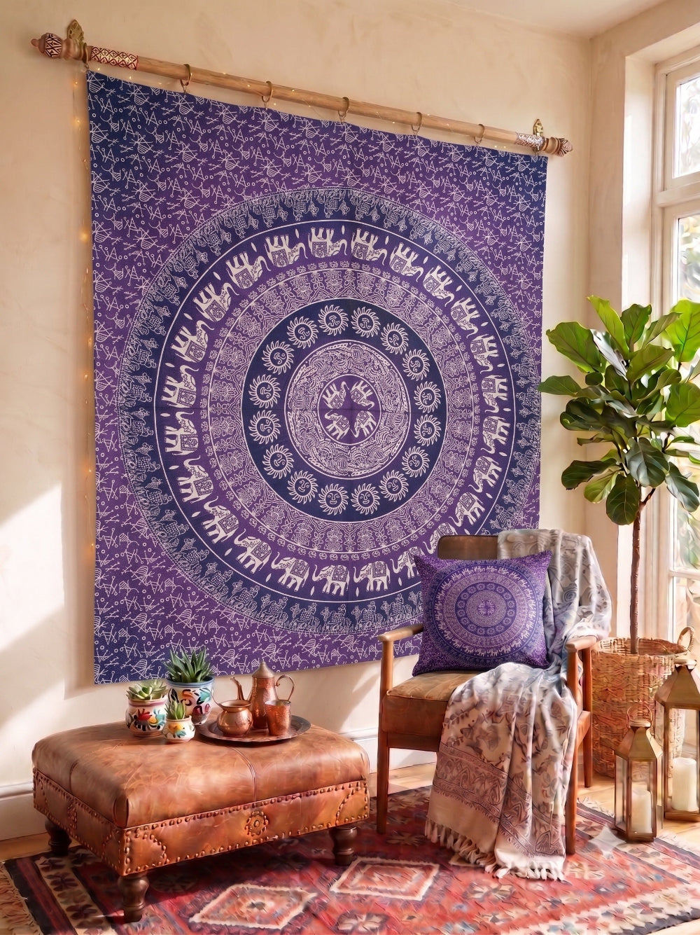 Purple mandala tapestry hanging on a wall in a room with a chair, ottoman, and plants.