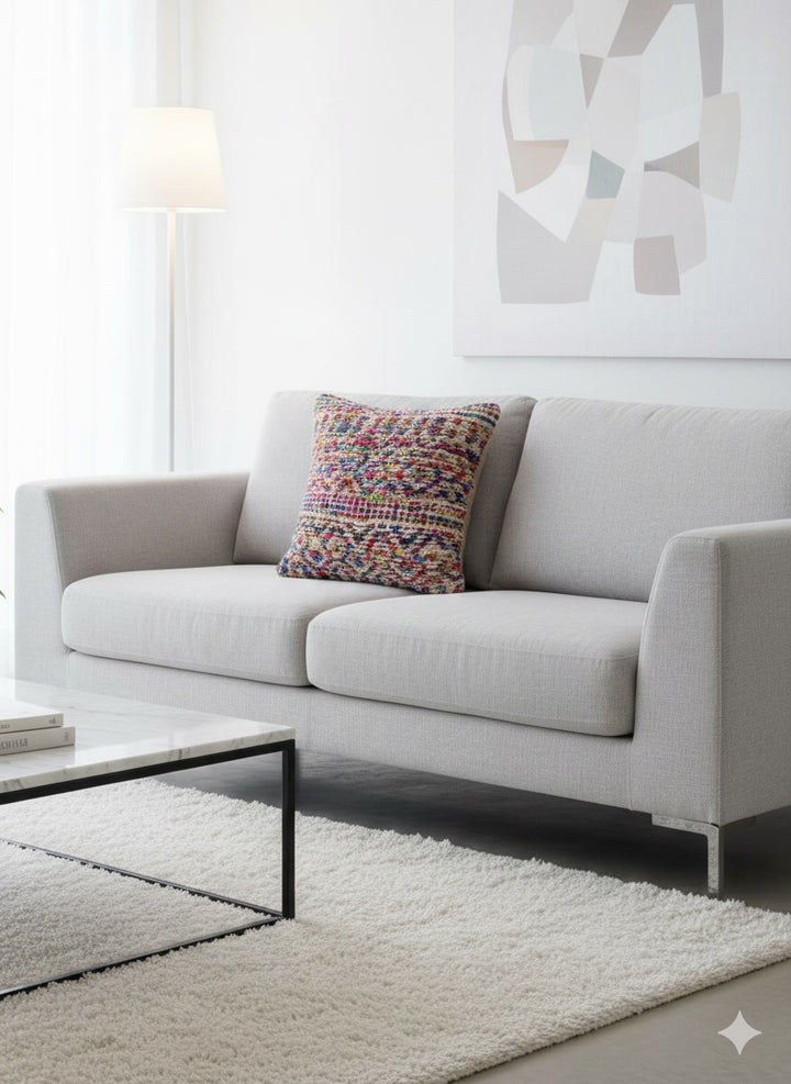 Gray sofa with a colorful pillow in a modern living room setting.