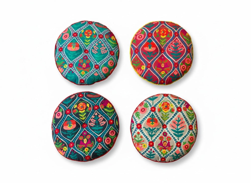 Four colourful cushions with floral patterns on a white background