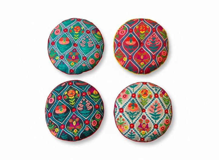 Four colourful cushions with floral patterns on a white background