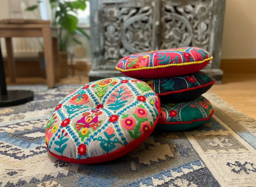 Colourful embroidered cushions on a patterned rug in a living room