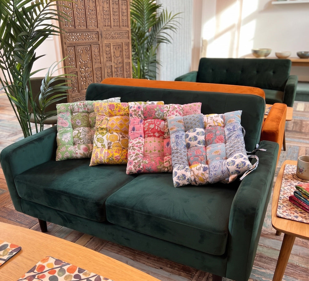Green sofa with colorful pillows in a living room setting