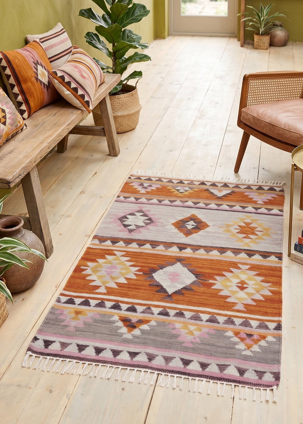 Living room with a patterned rug, wooden furniture, and plants.