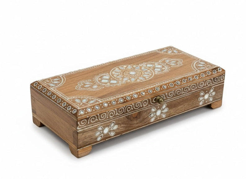 Wooden box with intricate white floral patterns on a white background