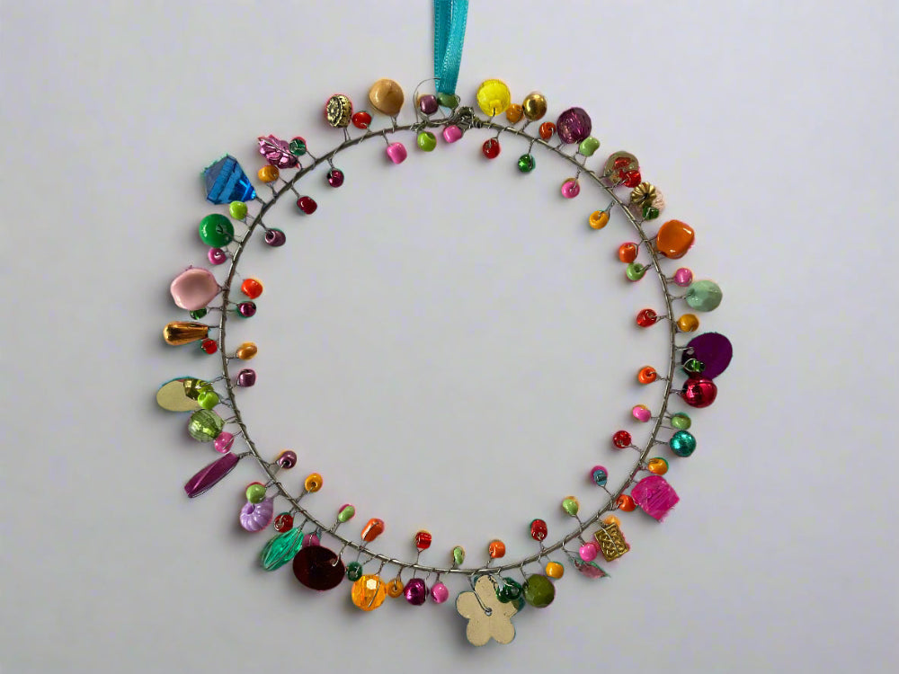 Decorative wreath with colourful beads and flowers on a white background