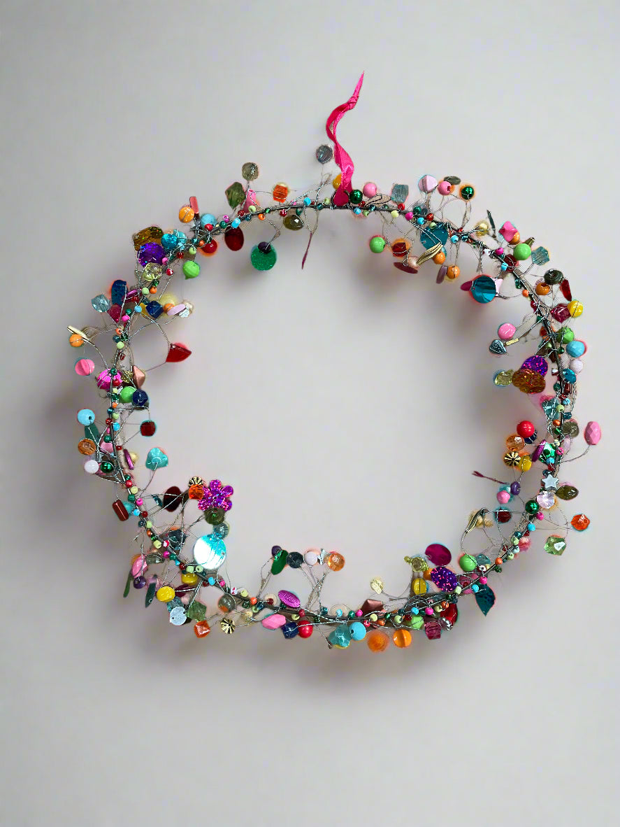 Colorful beaded wreath on a plain background