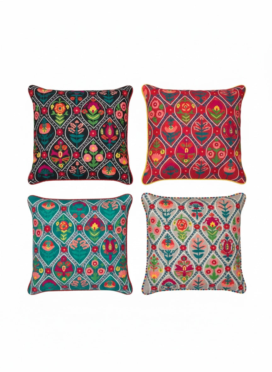 Set of four colourful patterned cushions on a white background