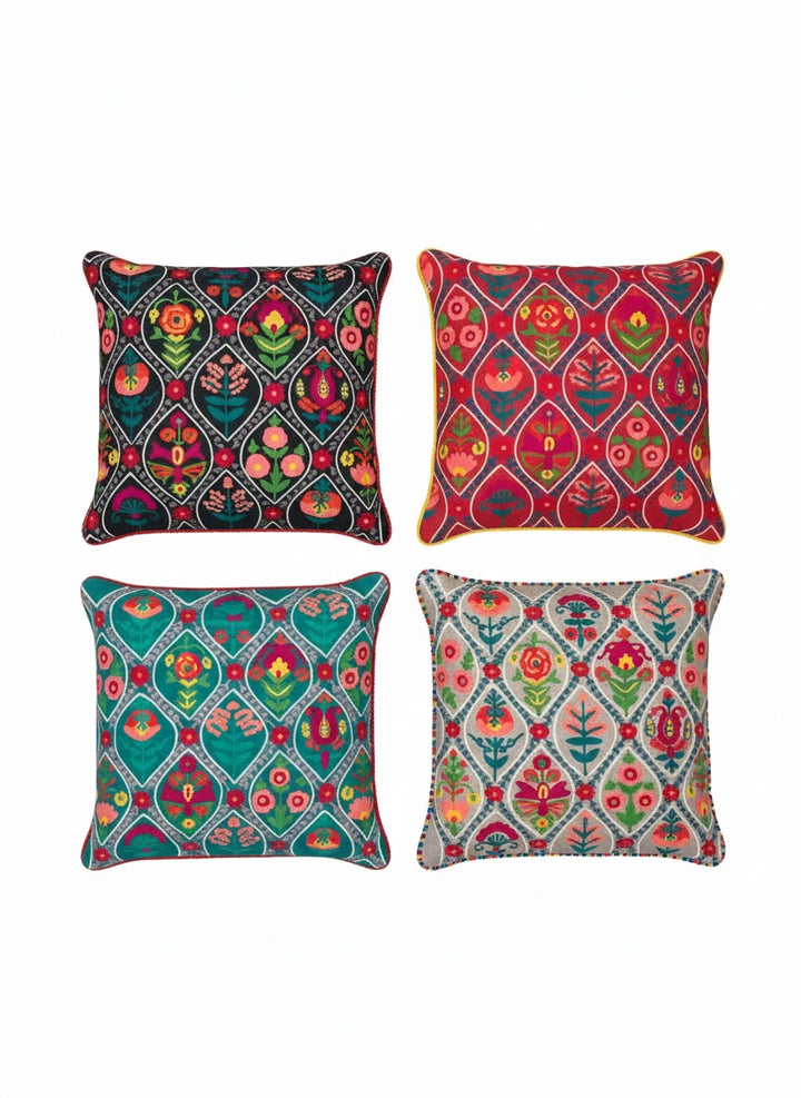 Set of four colourful patterned cushions on a white background