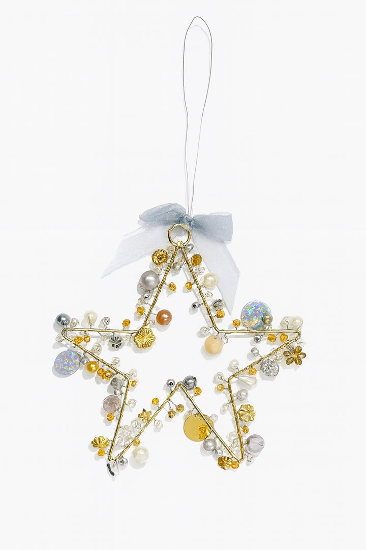 Decorative star ornament with beads and ribbons on a white background
