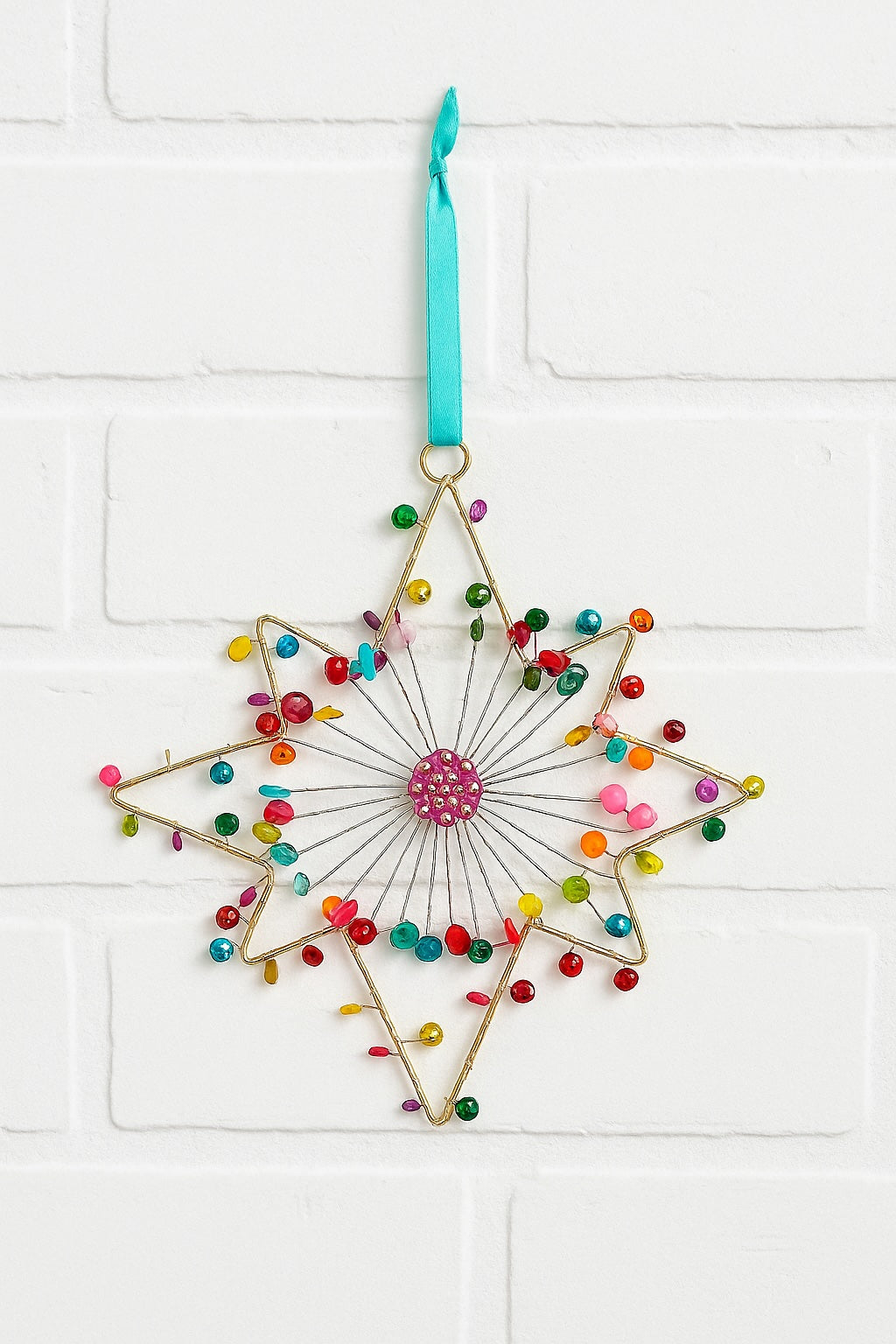 Decorative star-shaped ornament with colorful beads and a pink centre on a white background