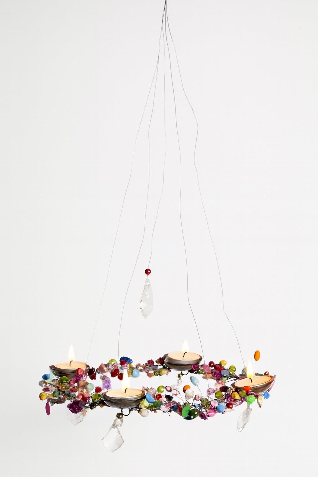 Hanging decorative chandelier with colourful beads and candles on a white background