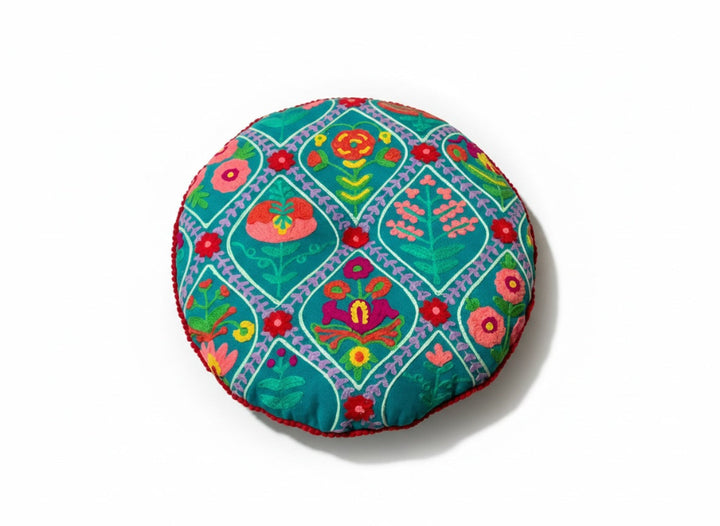 Round colourful cushion with floral patterns on a white background