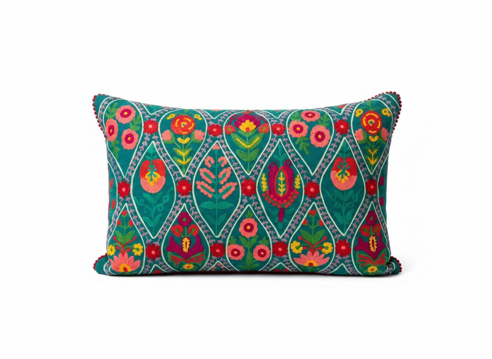 Decorative pillow with colourful teal floral pattern on a white background