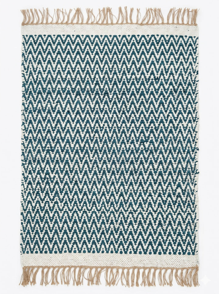 Teal and white chevron patterned rug with beige fringes on a plain background