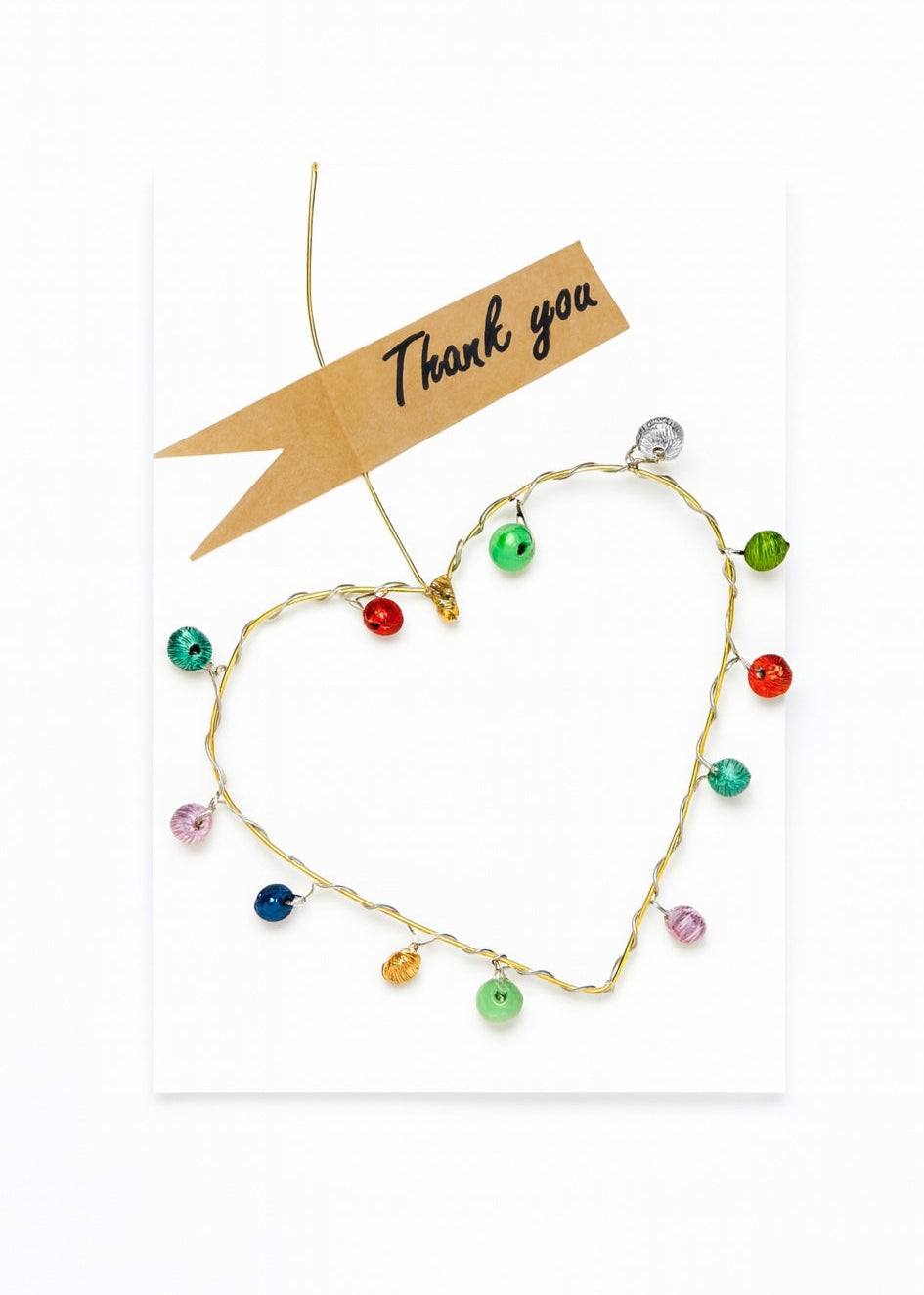 Colourful beaded wire heart on a white background with a 'Thank you' card.