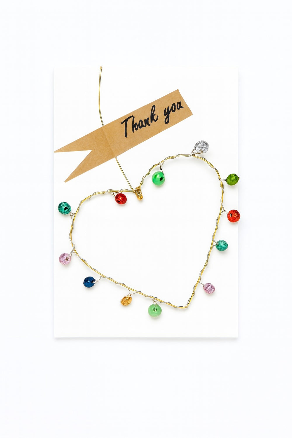 Colourful beaded heart on a white background with a 'thank you' card.