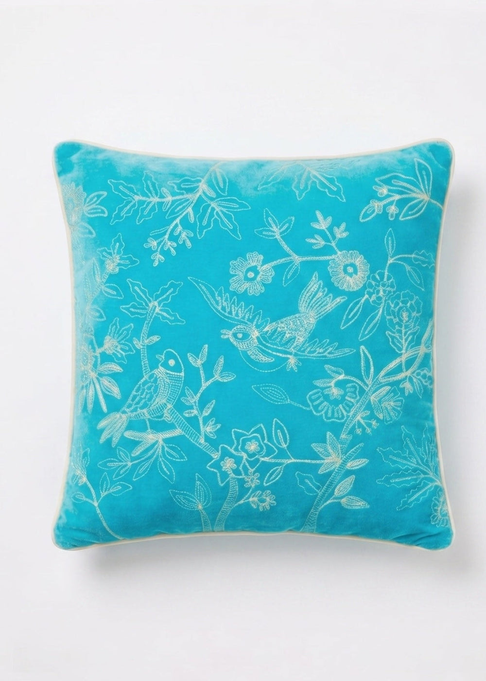 Turquoise pillow with floral and bird pattern on a white background