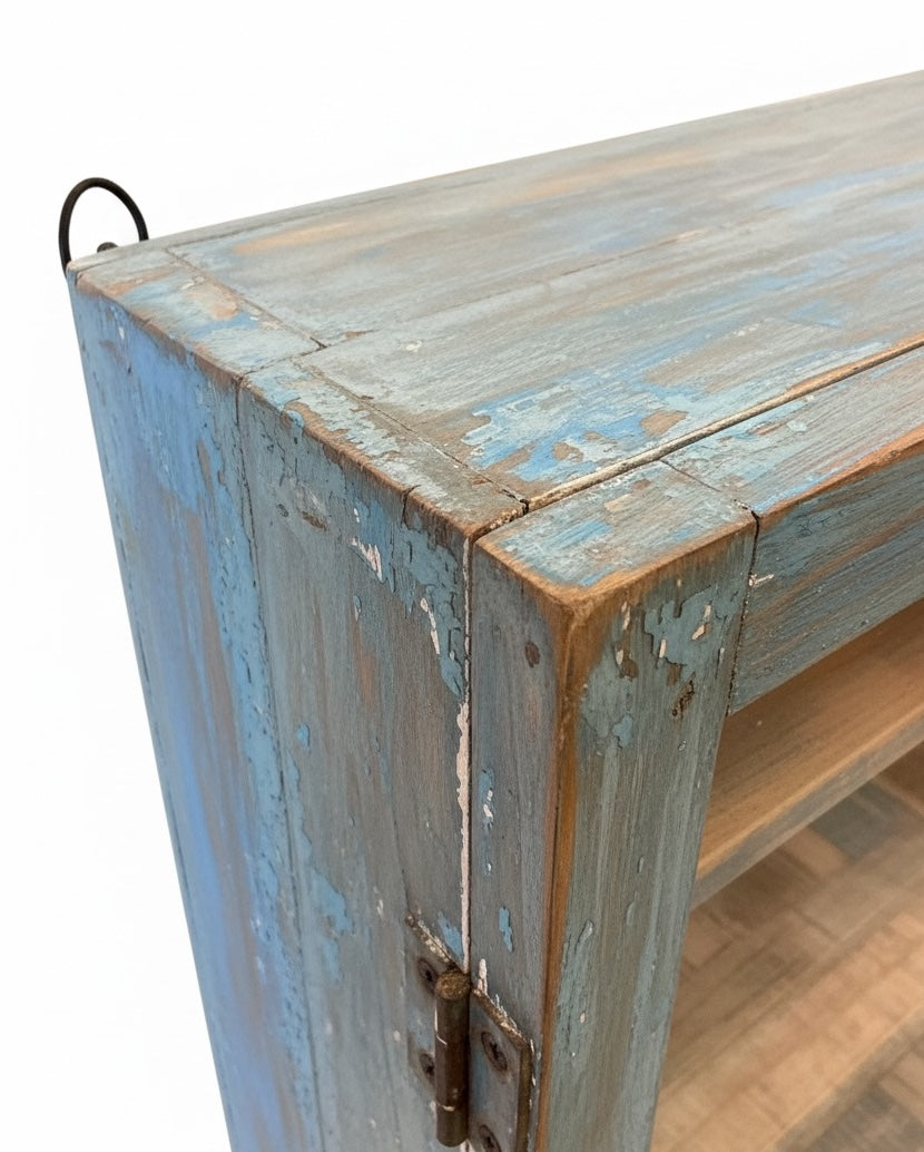 Vintage wooden cabinet with peeling blue paint on a white background