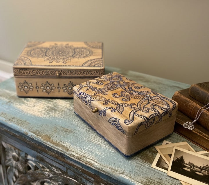 Decorative wooden boxes with intricate patterns on a rustic surface.
