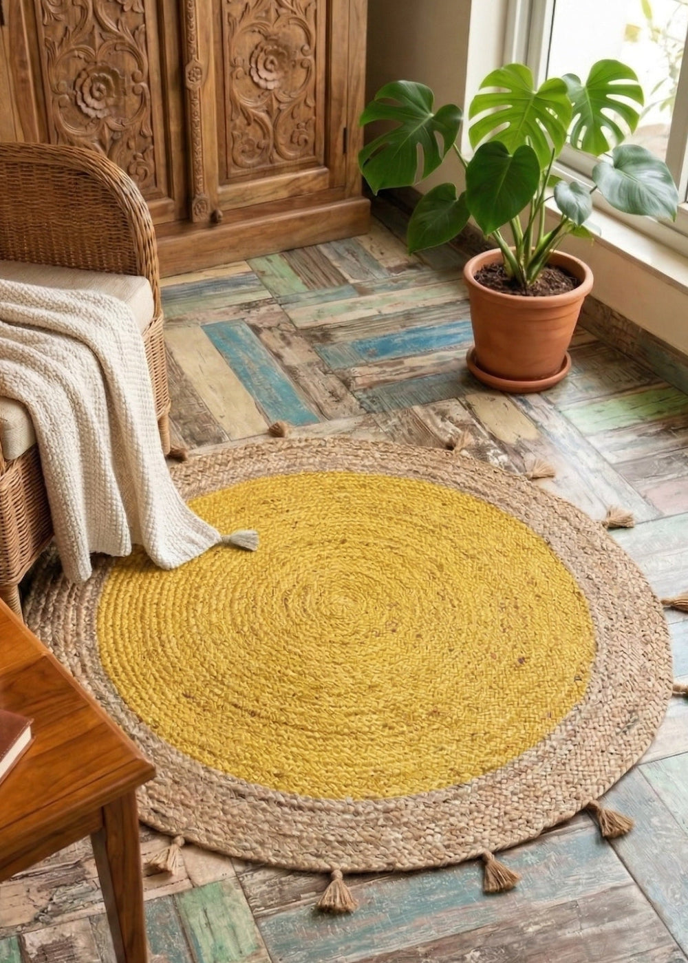 Round yellow rug on a wooden floor with a wicker chair and coffee table.