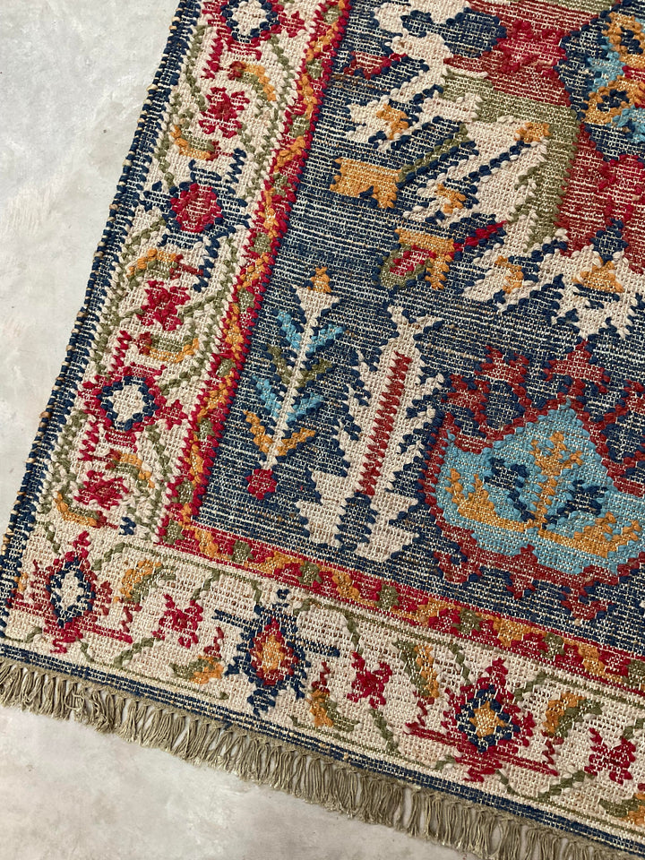 Close-up of a patterned rug with intricate designs on a textured surface