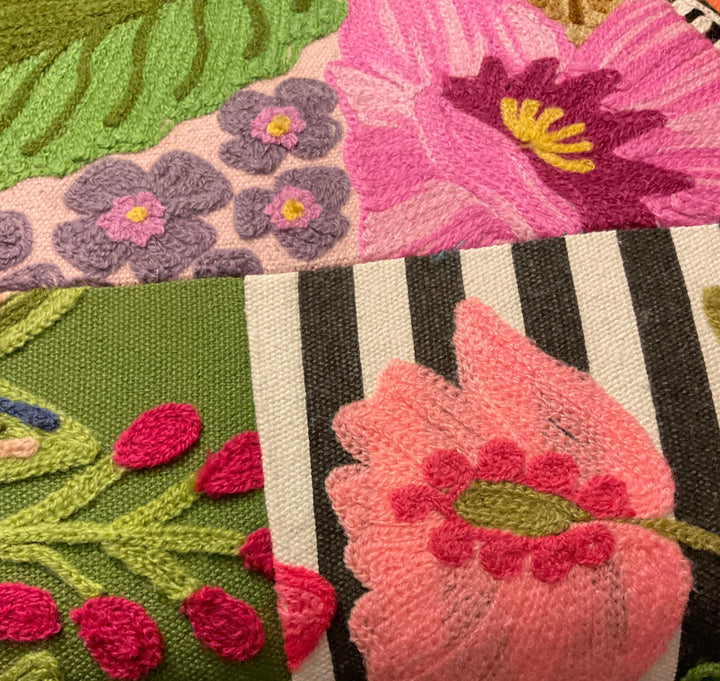 Close-up of a textured fabric with floral patterns in pink, purple, green, and black.