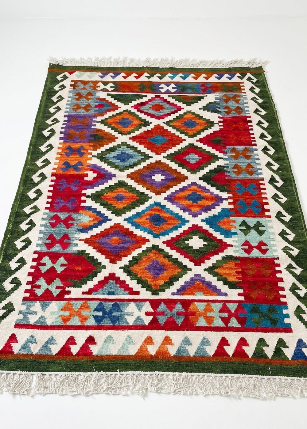 ColoUrful geometric patterned rug with green border on a white background
