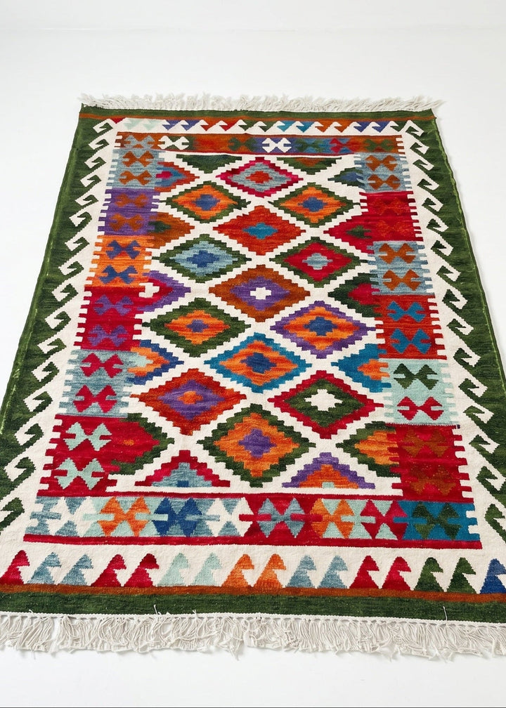 ColoUrful geometric patterned rug with green border on a white background