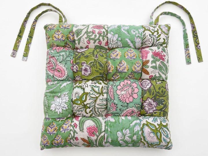 Green floral patterned chair pad with straps on a white background