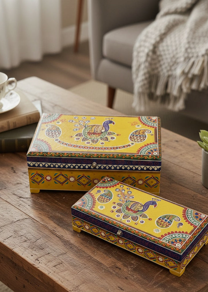 Decorative yellow boxes with intricate patterns on a wooden table.