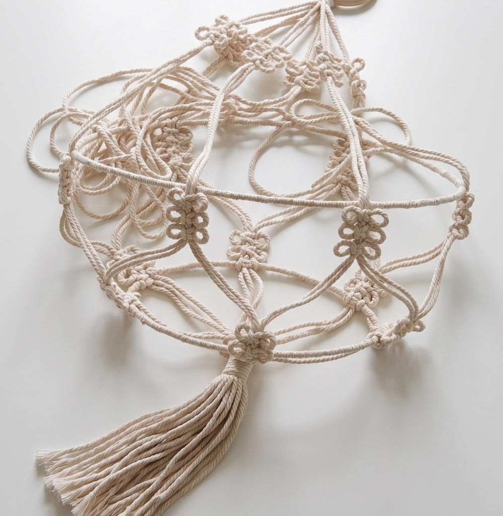 Macrame plant jute hanging with tassels on a light background