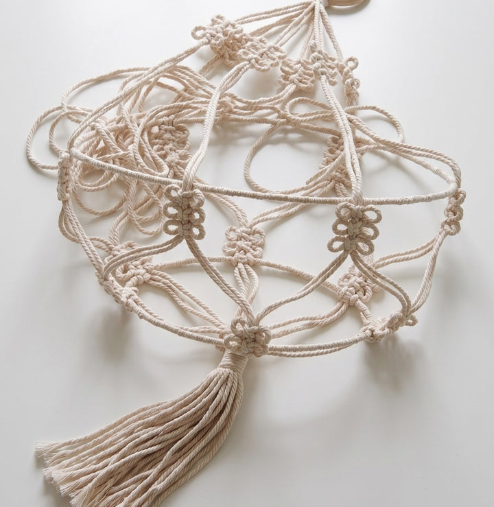 Macrame plant jute hanging with tassels on a light background