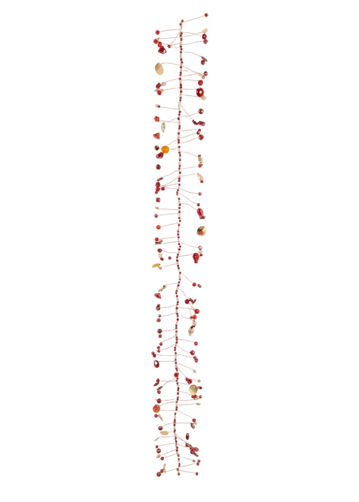A long, narrow decorative garland or wall hanging made of many thin red string lines with small red berries and scattered natural shell-like beads, photographed against a plain white background.
