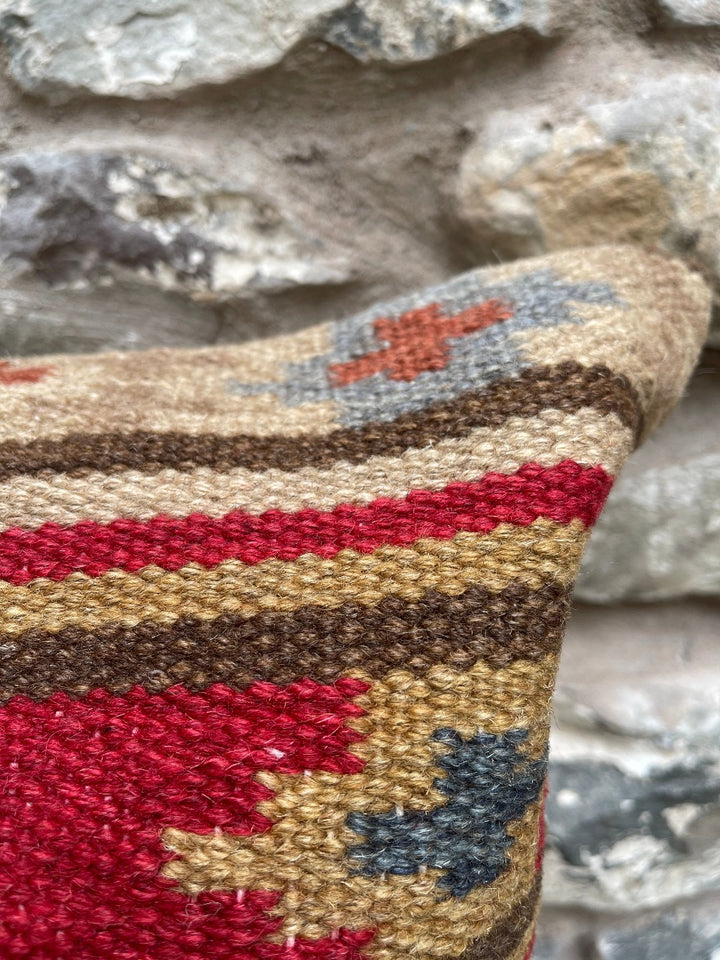 Close up of kilim cushion cover weave against stone wall